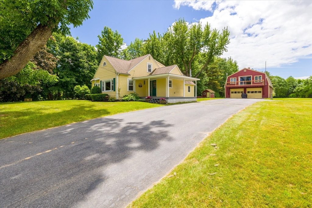 a front view of a house with a yard and trees