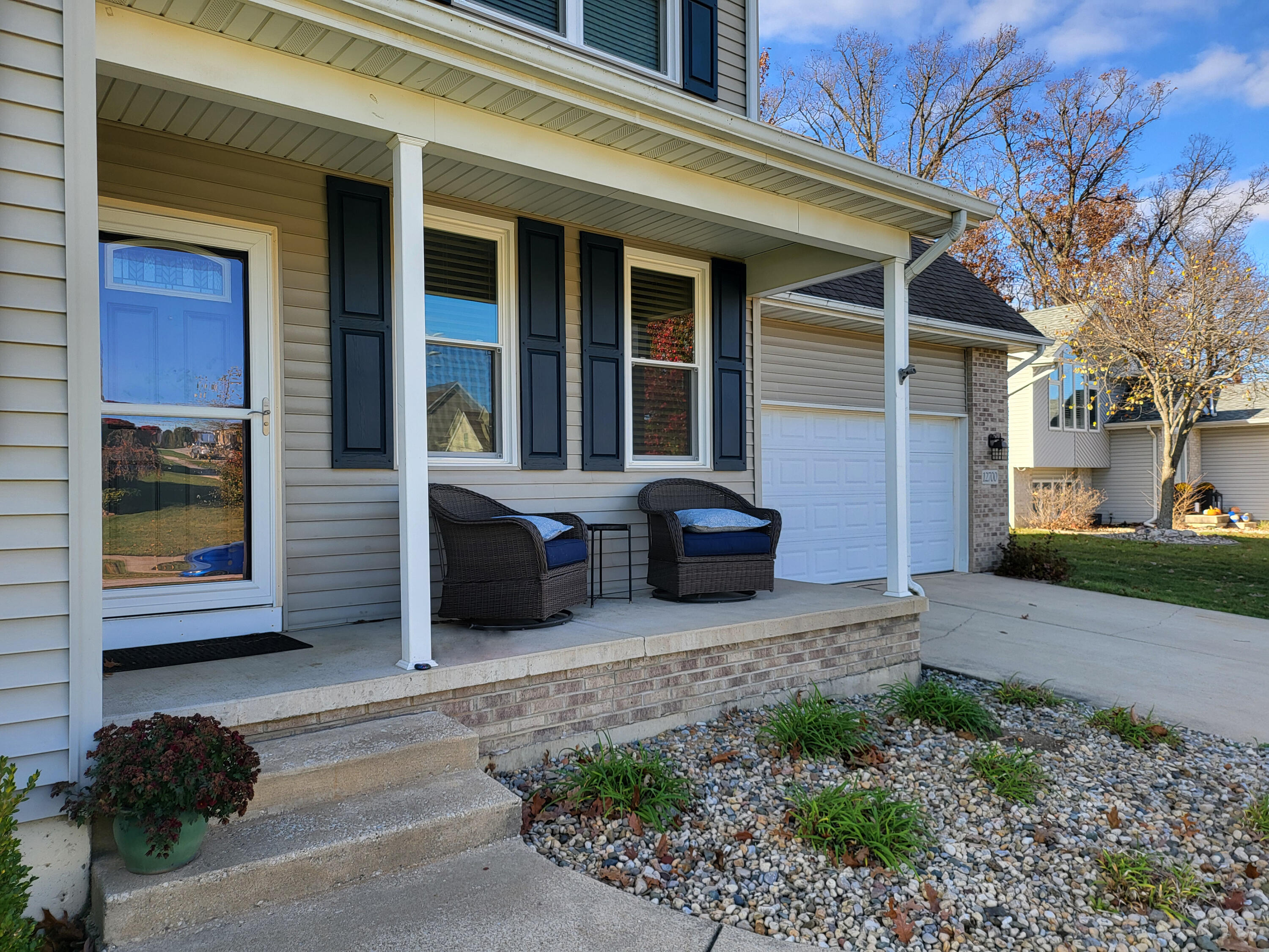 a couple of potted plants in front of a brick house