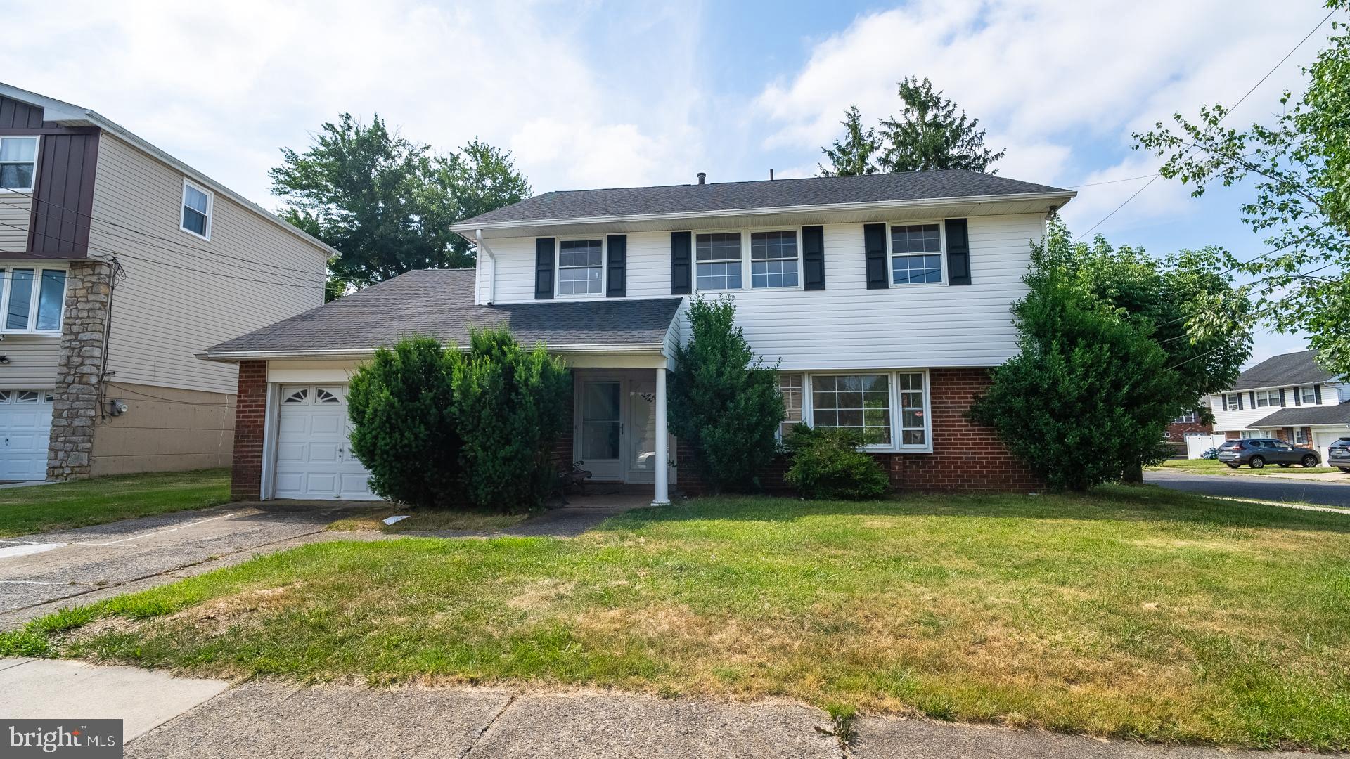 a view of a house with a yard and potted plants