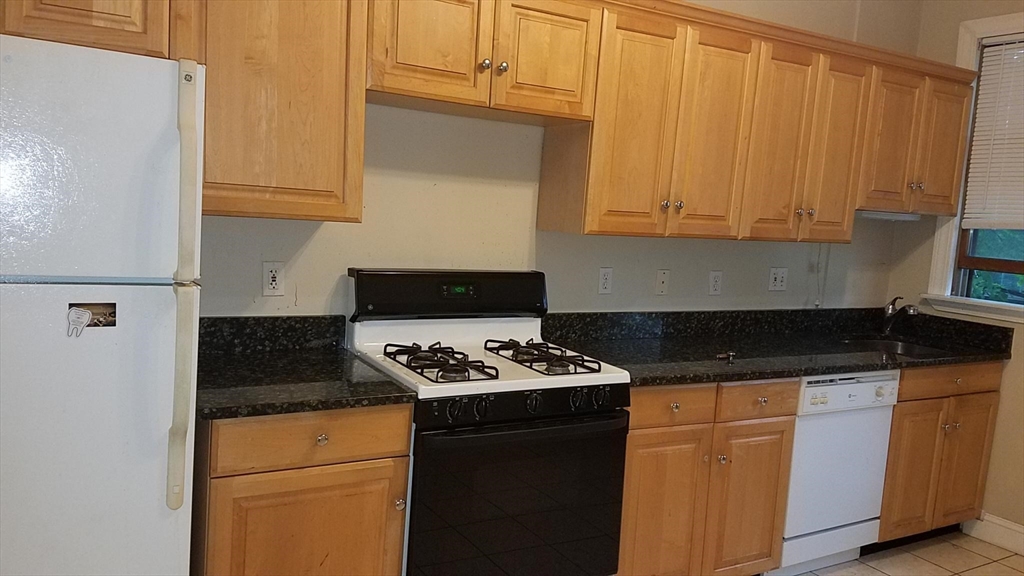 a kitchen with granite countertop cabinets and black appliances