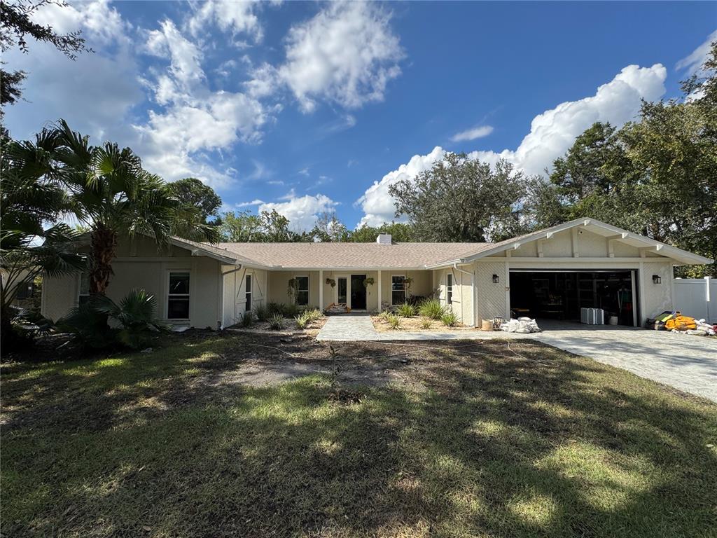 a front view of a house with yard and trees