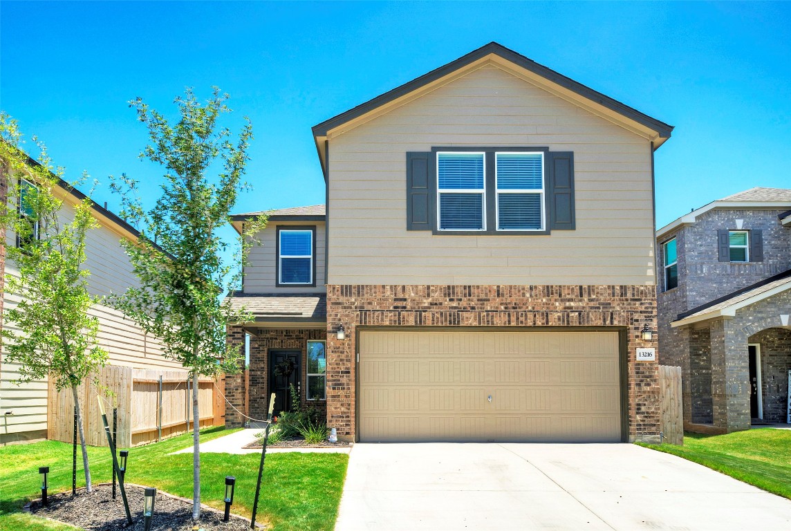 a front view of a house with a yard and garage