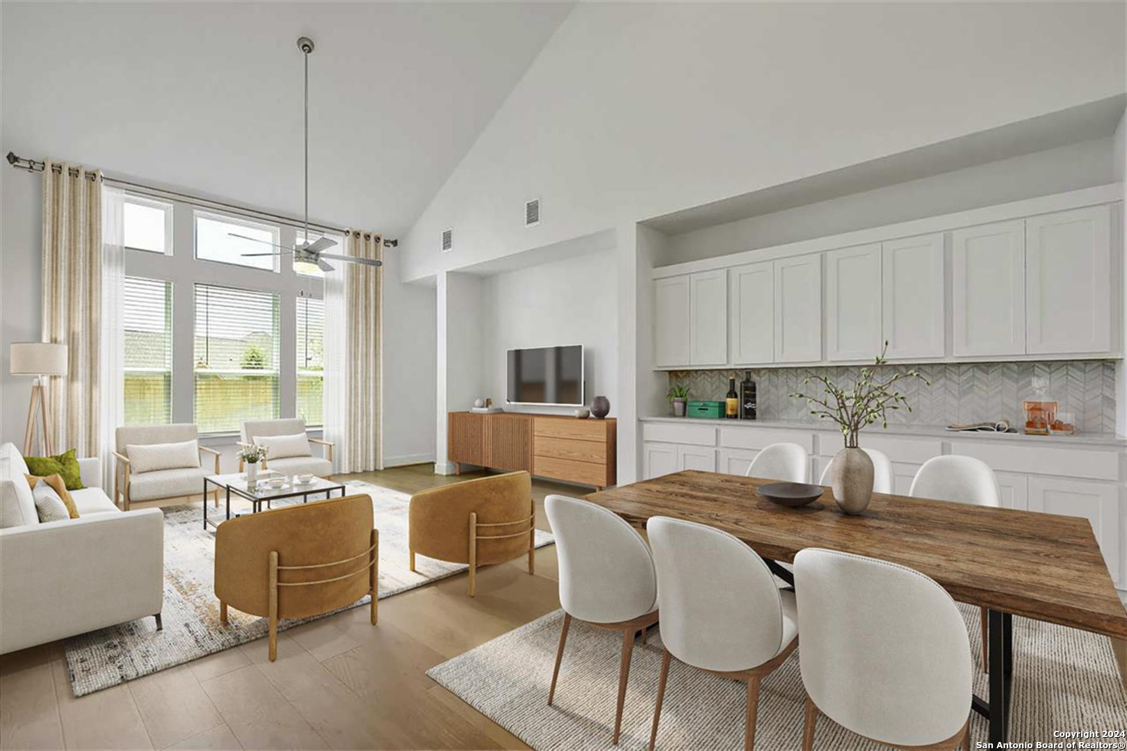 a kitchen with granite countertop a dining table chairs and white cabinets