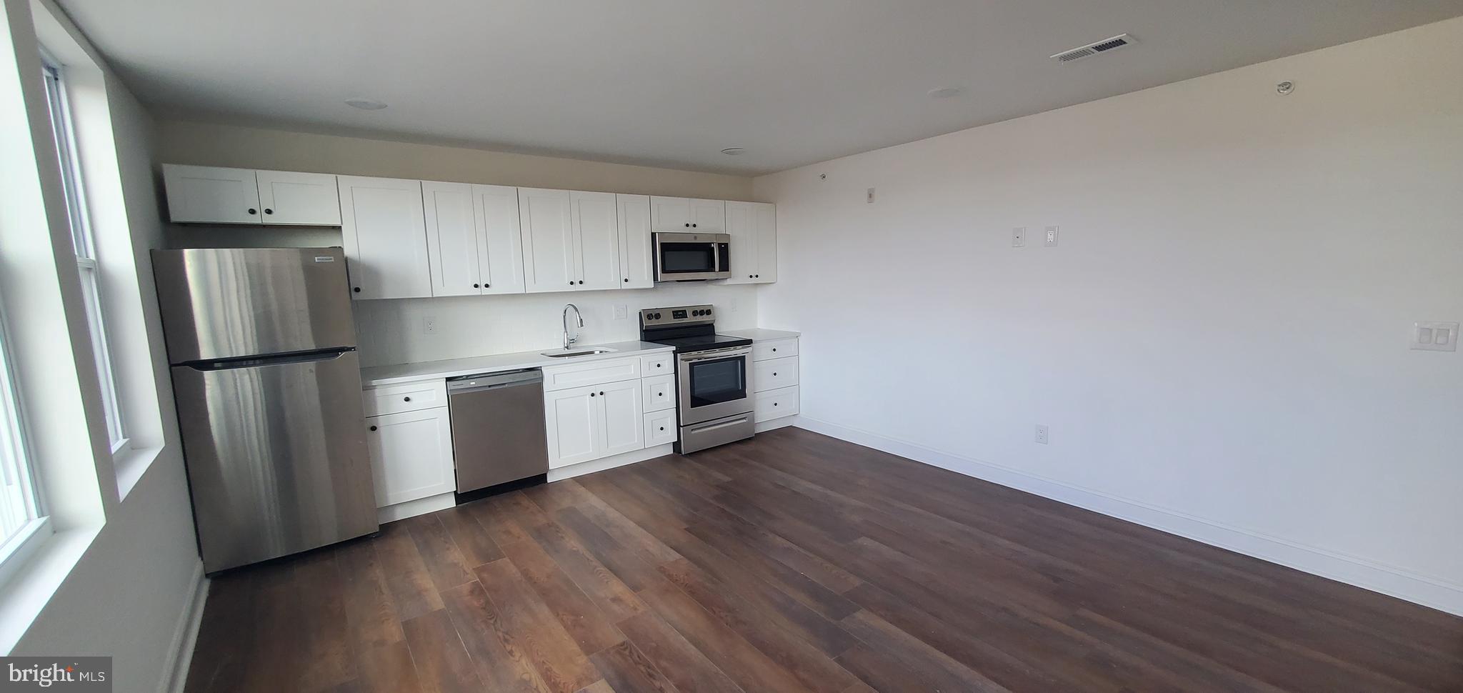 a kitchen with stainless steel appliances a refrigerator sink and cabinets