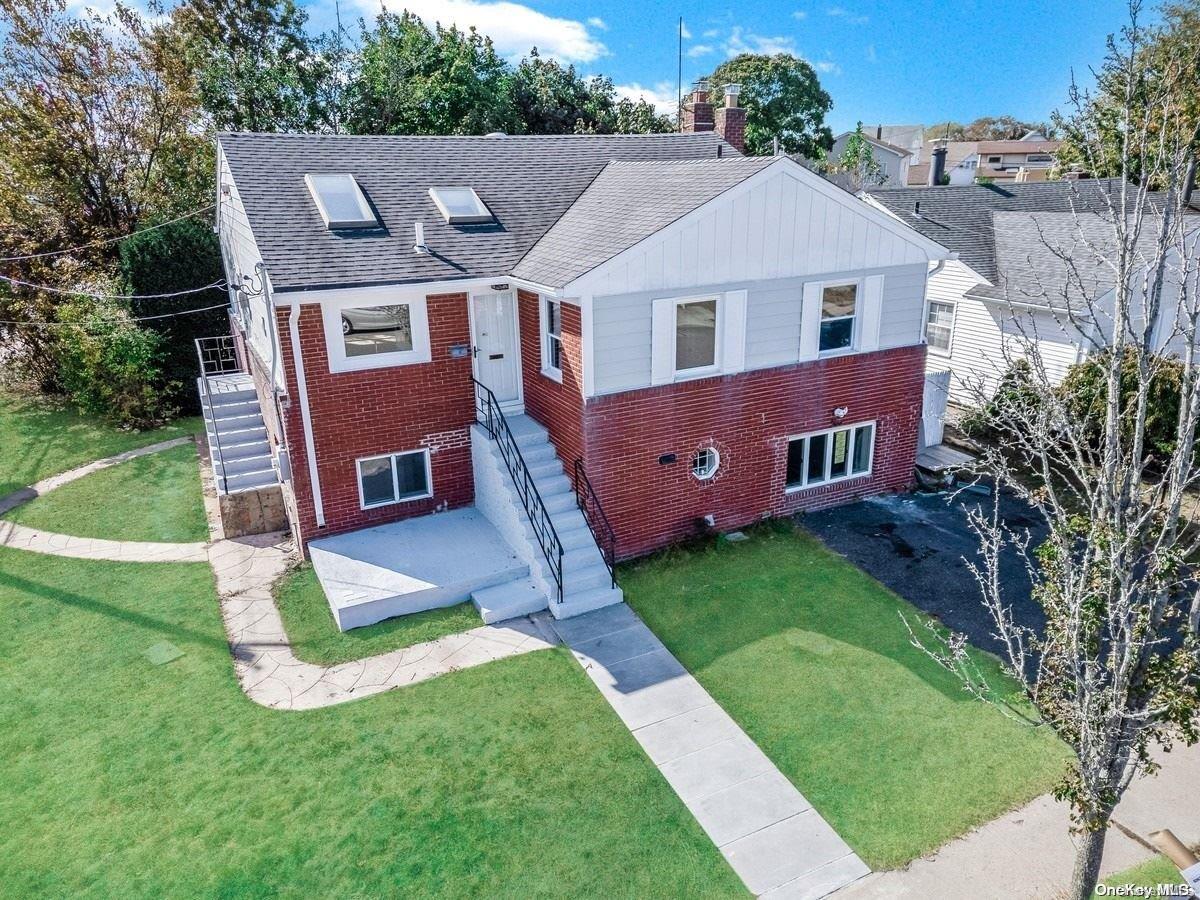 a aerial view of a house with a yard table and chairs