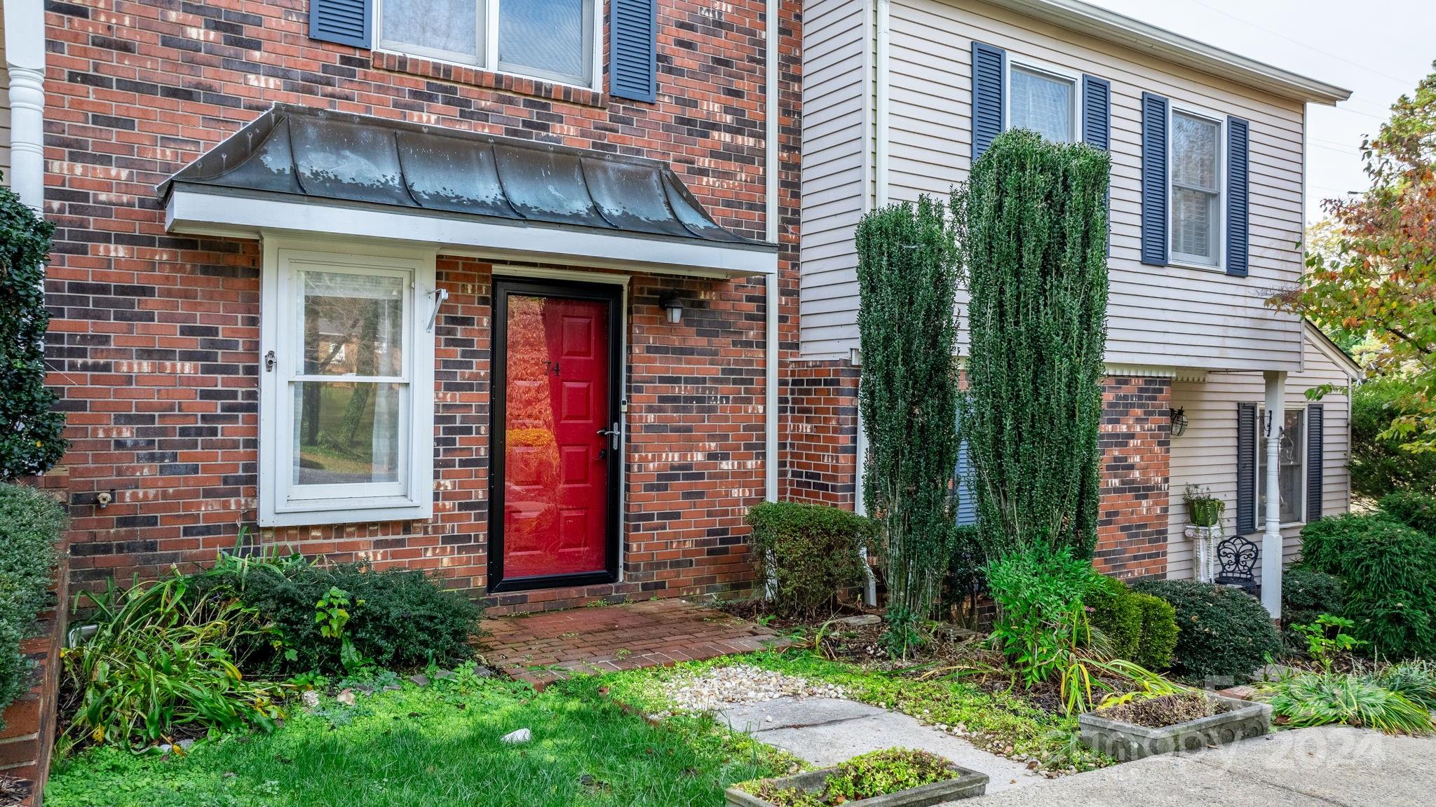 front view of a brick house with a yard