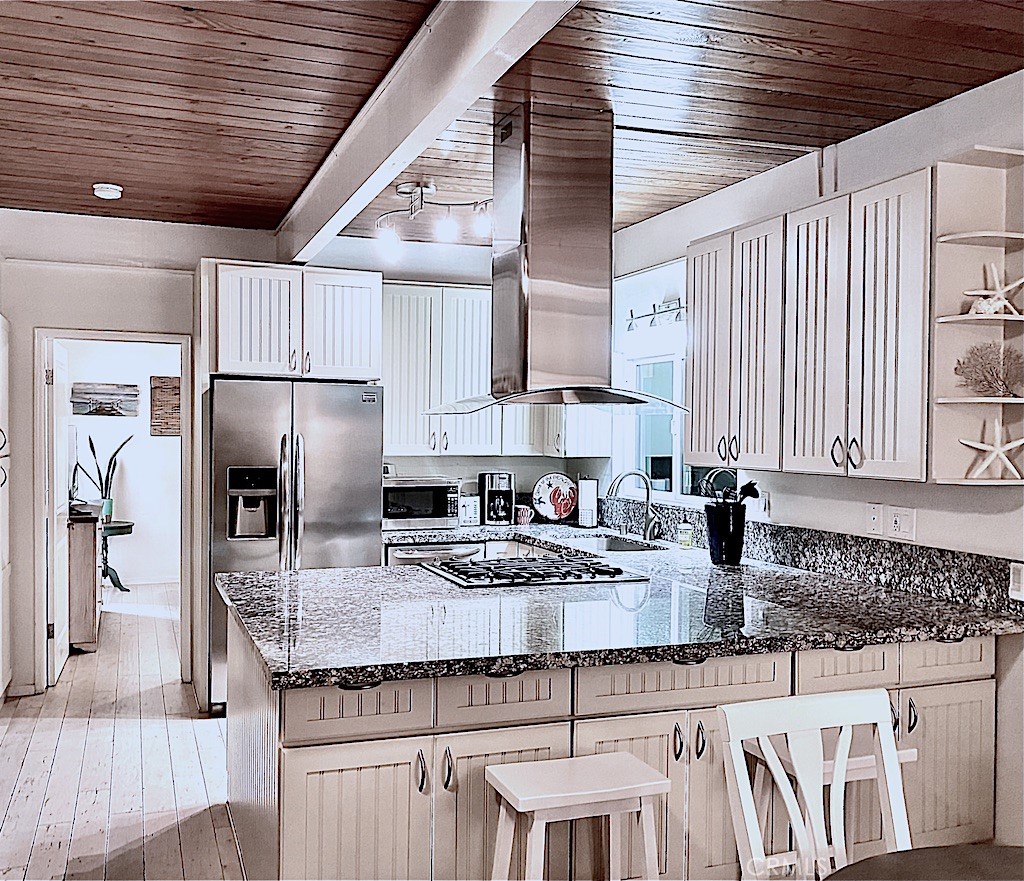 a kitchen with kitchen island granite countertop a sink stainless steel appliances and cabinets