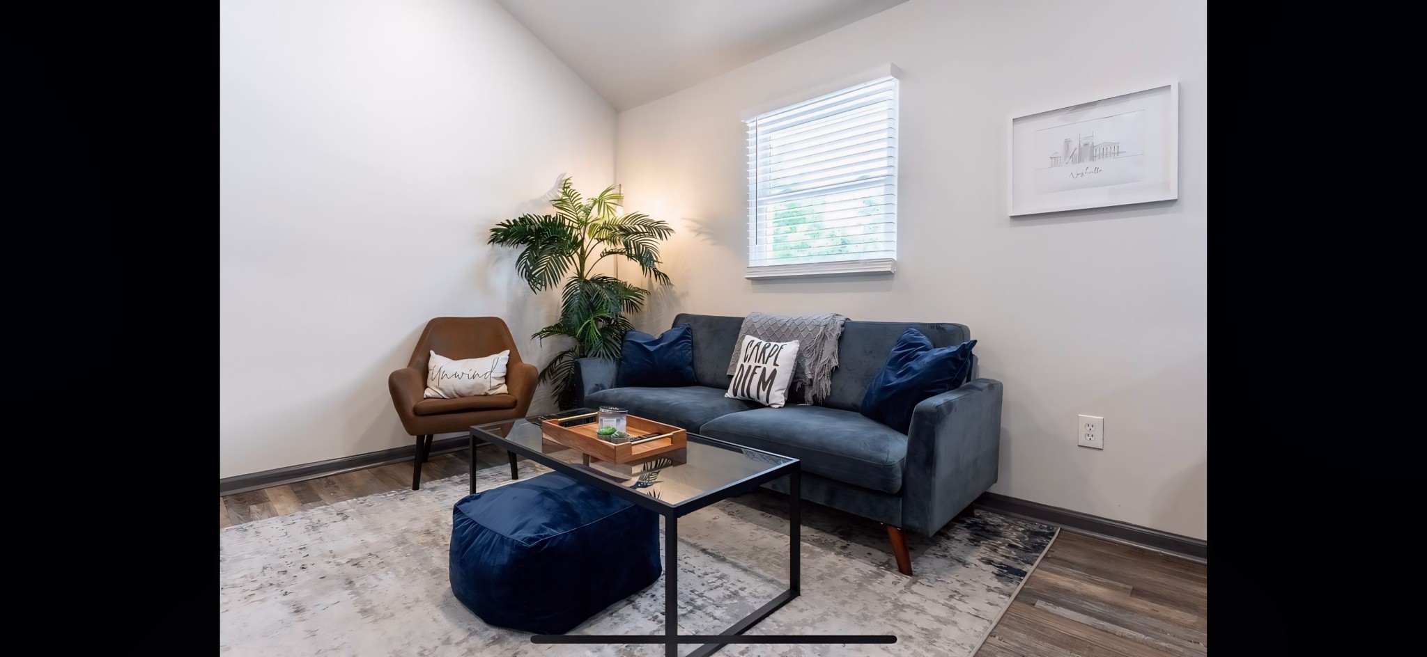 a living room with furniture a window and a potted plant