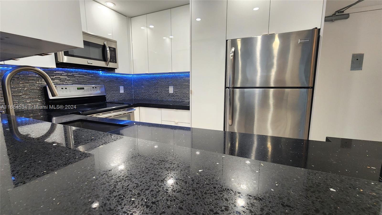 a kitchen with stainless steel appliances a refrigerator and a stove top oven