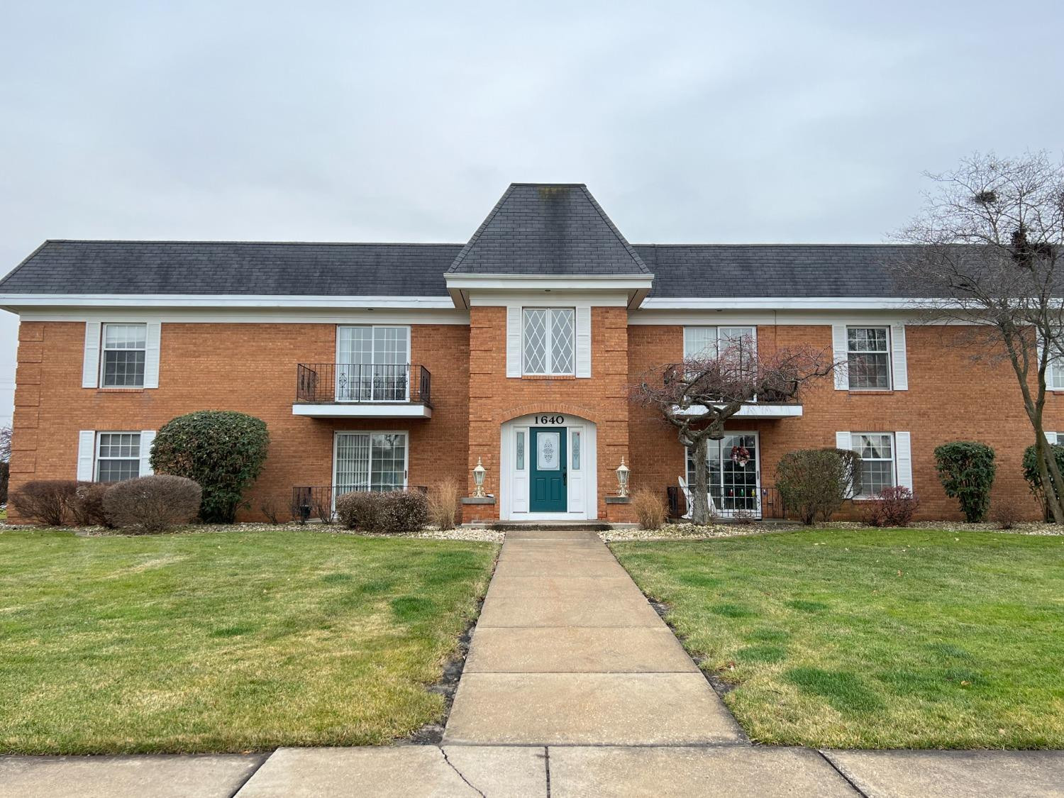 front view of a brick house with a yard