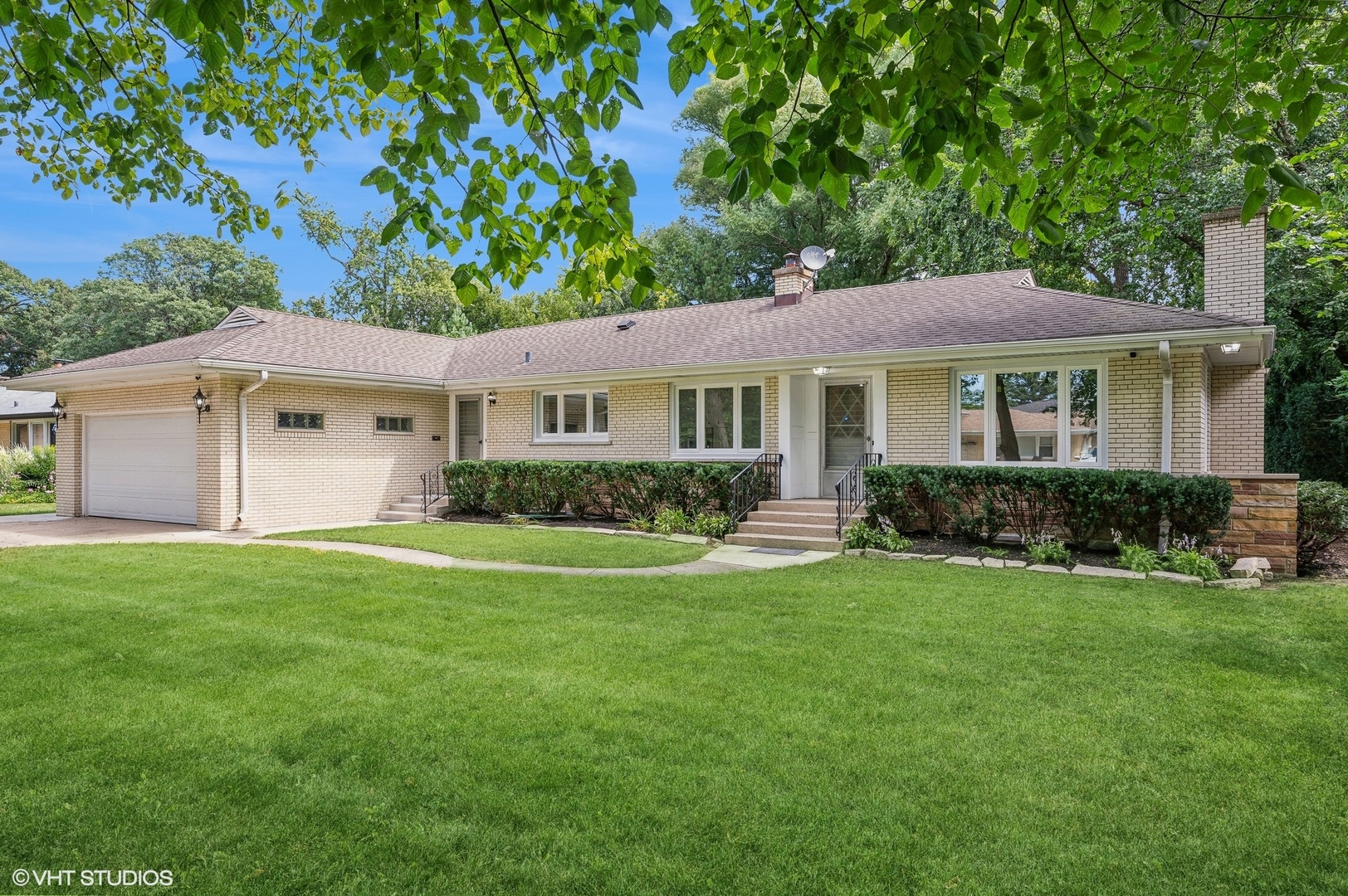 a view of a house with a yard and potted plants