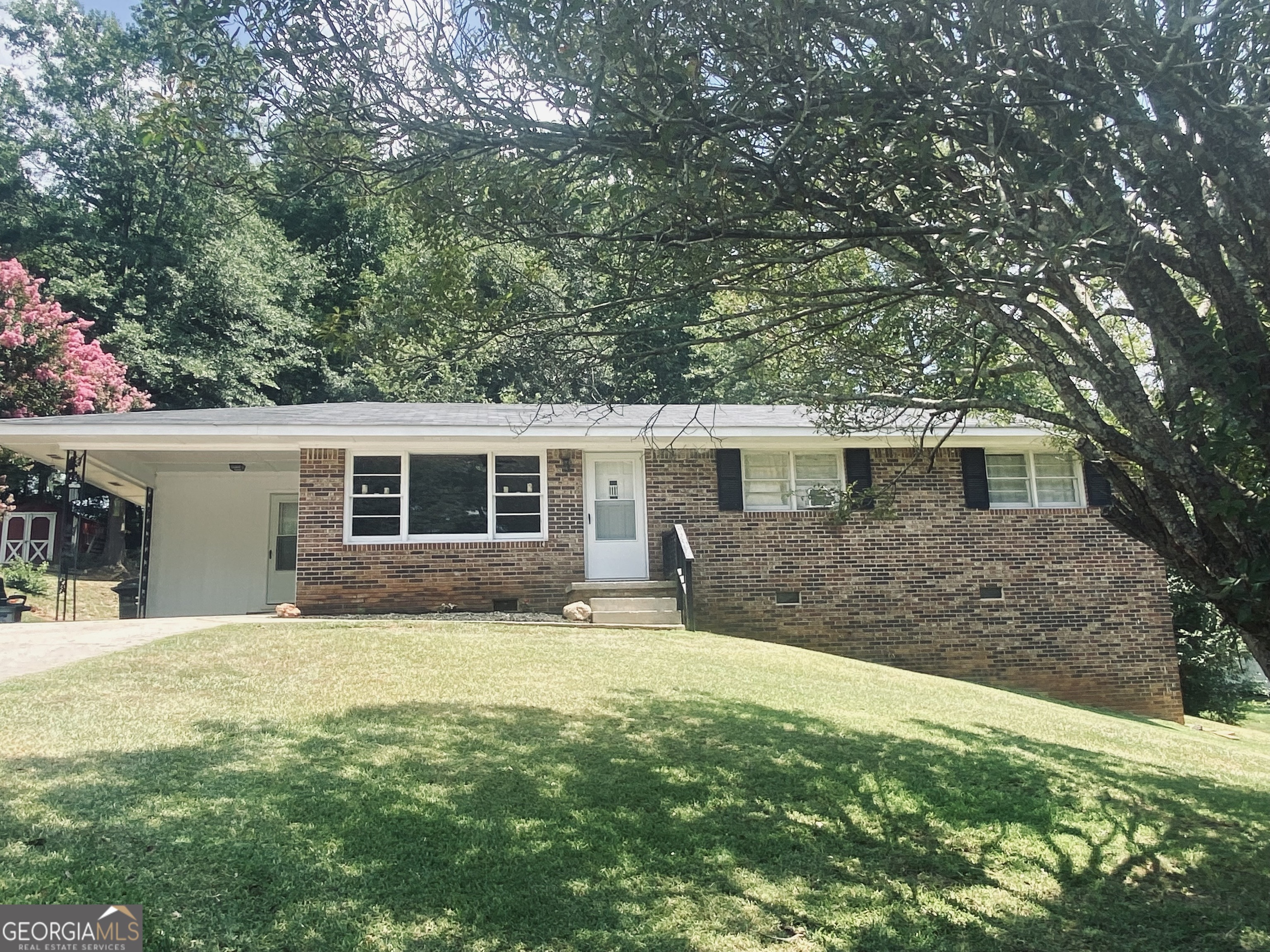 a front view of house with yard and trees in the background