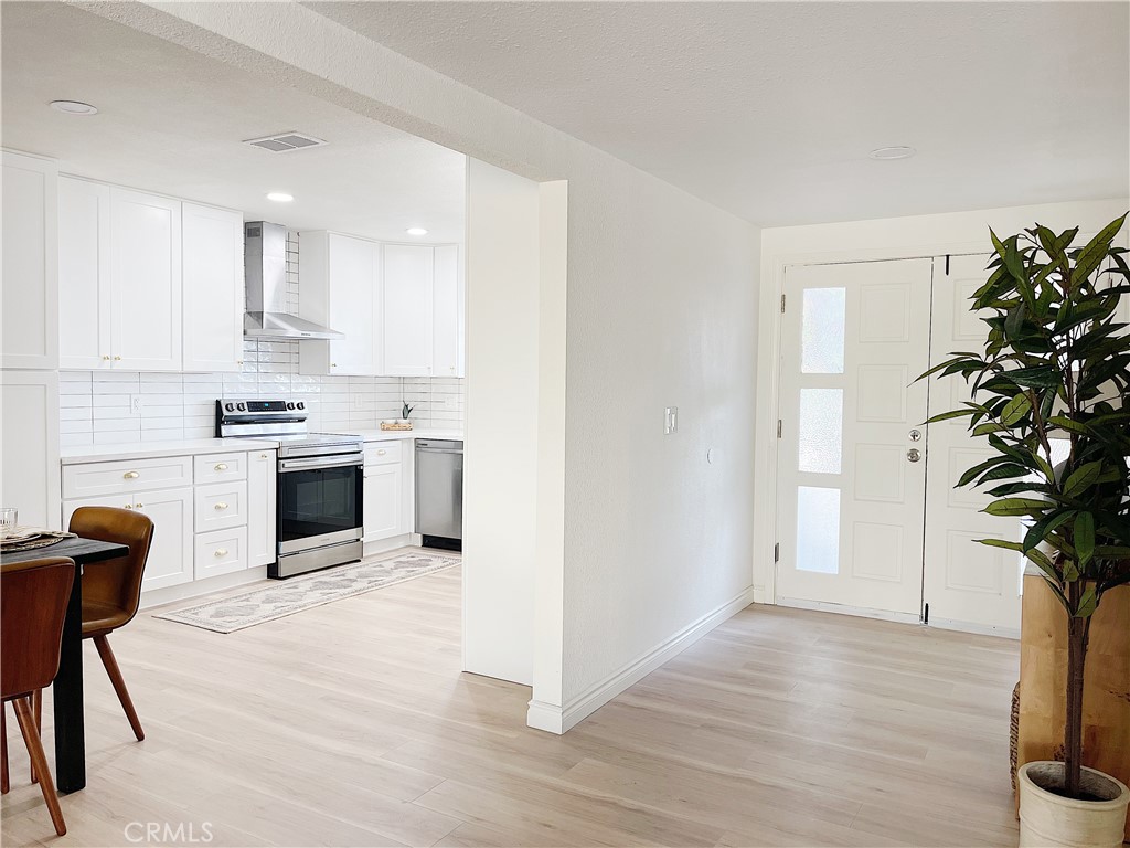 a kitchen with white cabinets and appliances