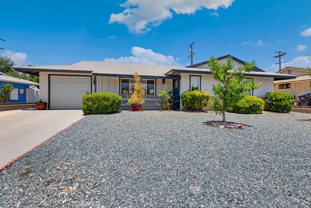 a front view of a house with a yard and potted plants