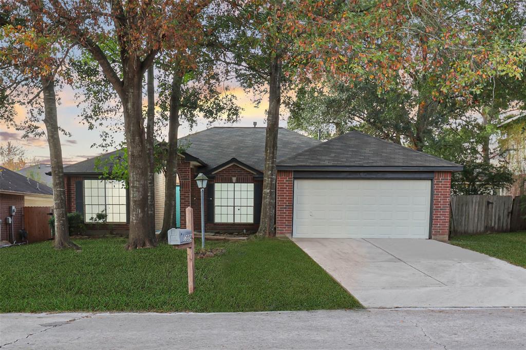 Charming brick home with a double garage, nestled among mature trees. Features a well-maintained front lawn and large windows, offering a welcoming curb appeal Note