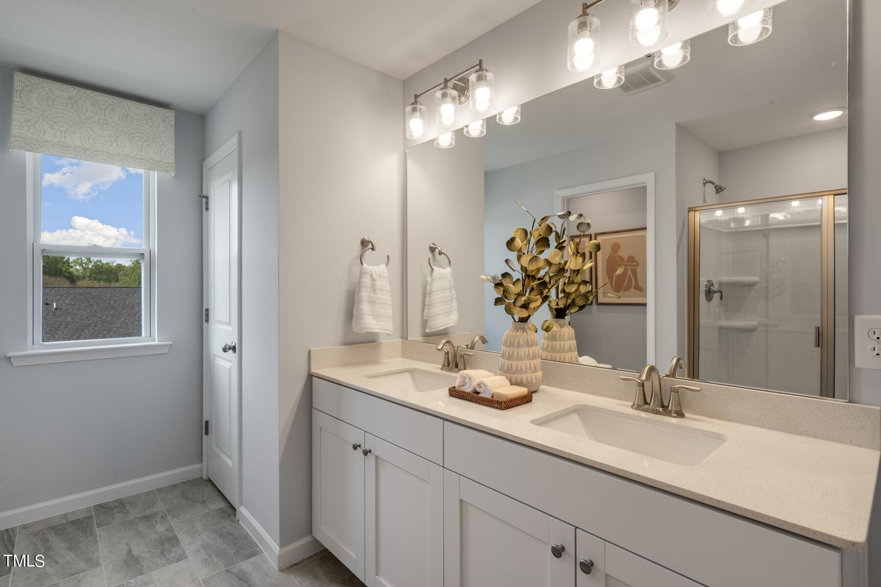 a bathroom with a sink double vanity and a mirror