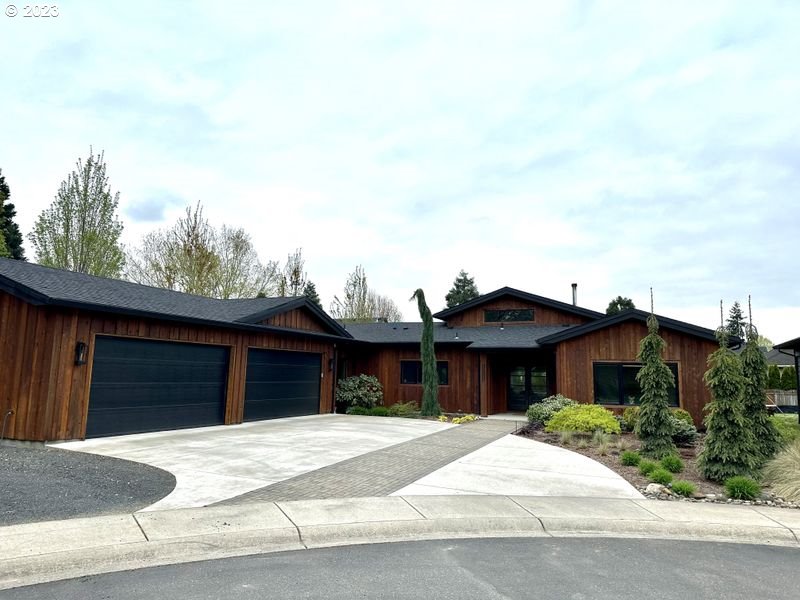 a view of house with a yard and a parking space