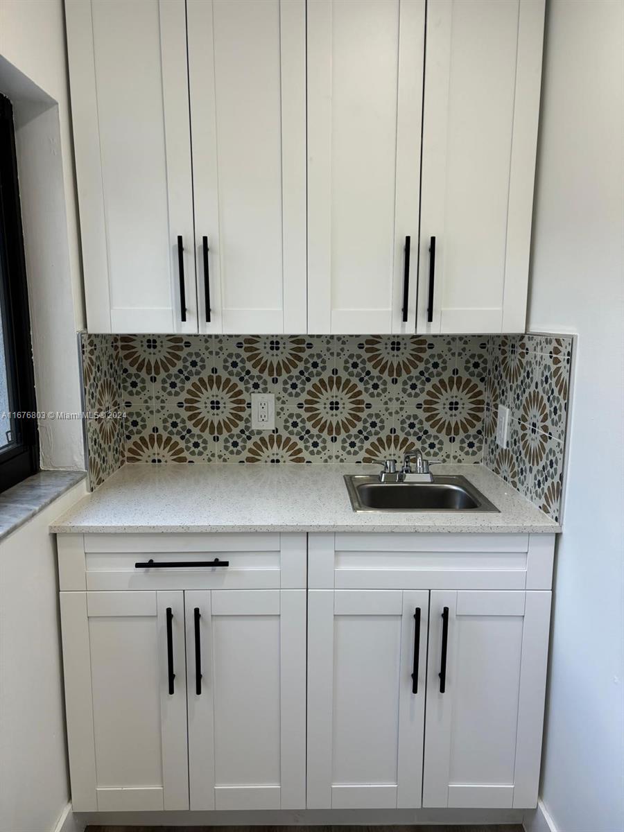 a view of white cabinets and sink