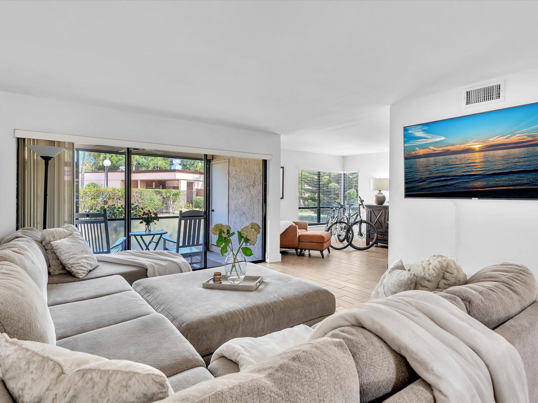 a living room with furniture large window and flat screen tv