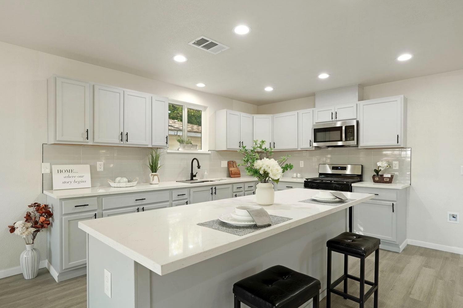 a kitchen with a sink a stove cabinets and wooden floor