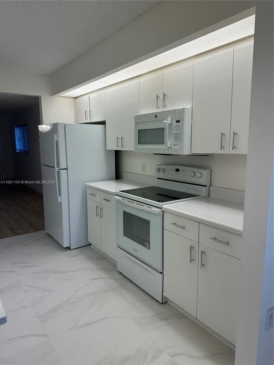 a kitchen with cabinets and white stainless steel appliances