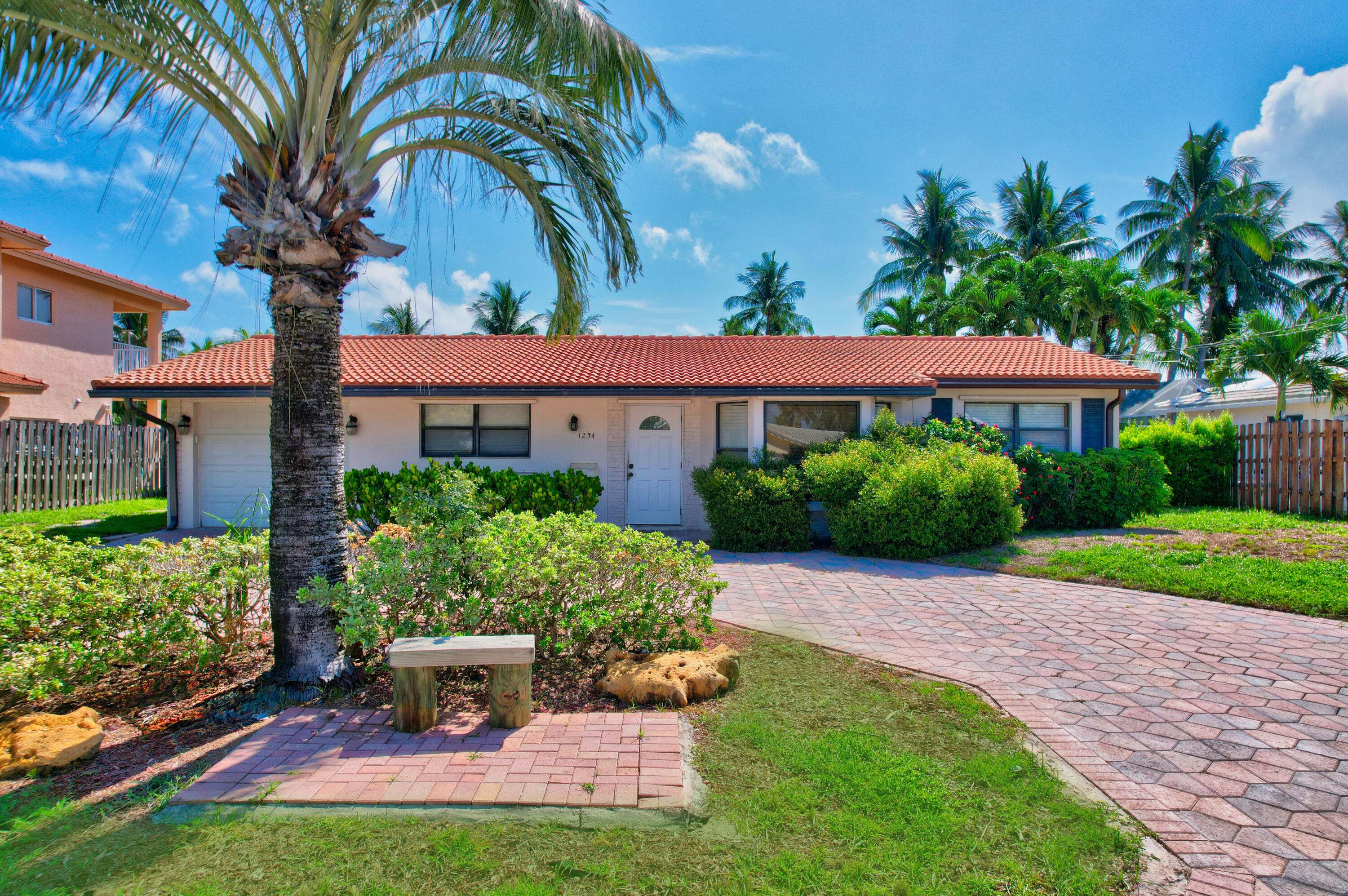 a front view of a house with a yard and potted plants