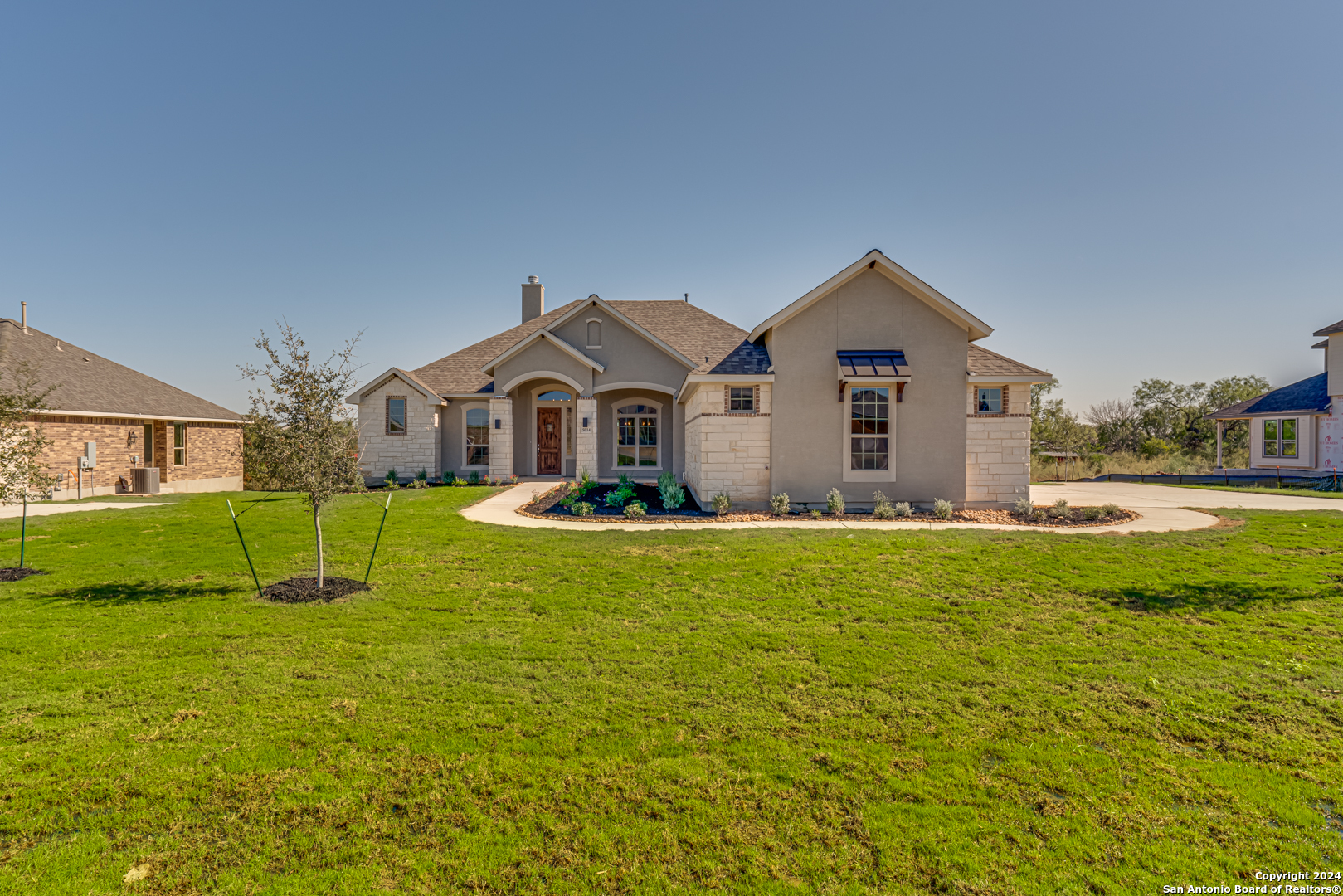 a view of a house with a big yard and large trees