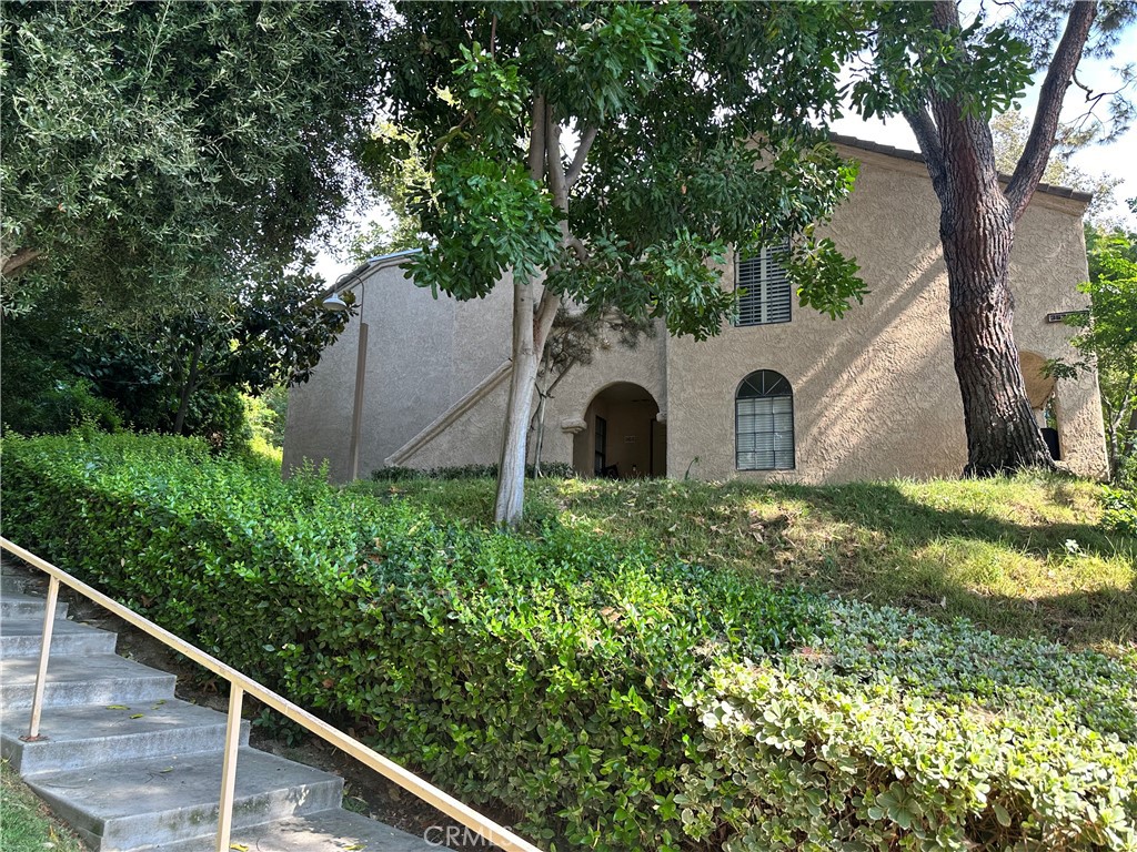 a view of a yard with large trees and a barn