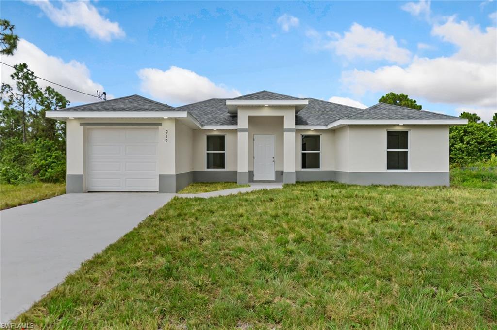 View of front of home featuring a garage and a front yard