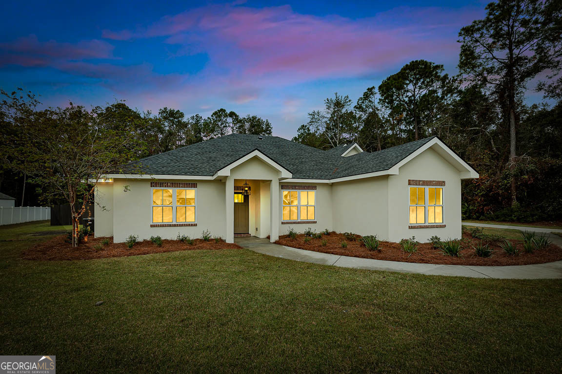 a front view of a house with a yard and trees