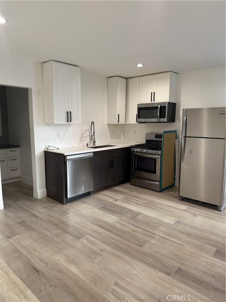 a large kitchen with cabinets and stainless steel appliances