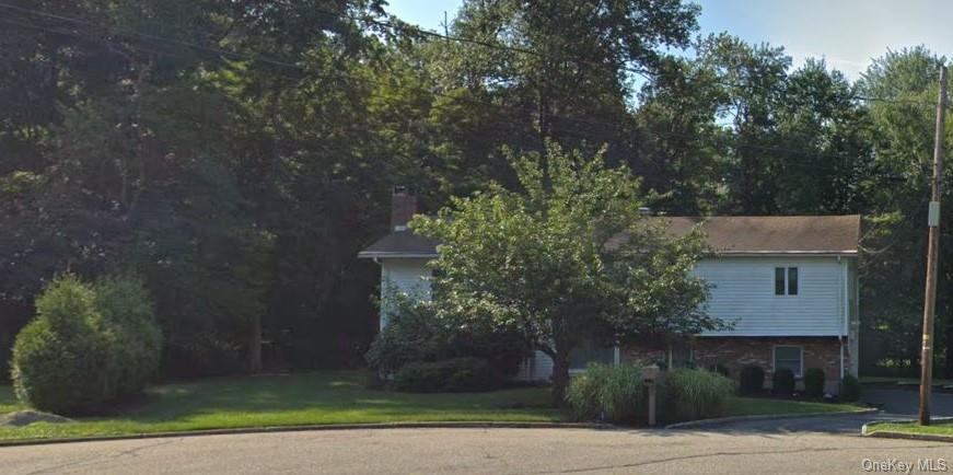 View of property exterior with a lawn