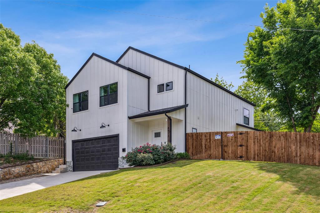 a view of a house with wooden fence and a yard