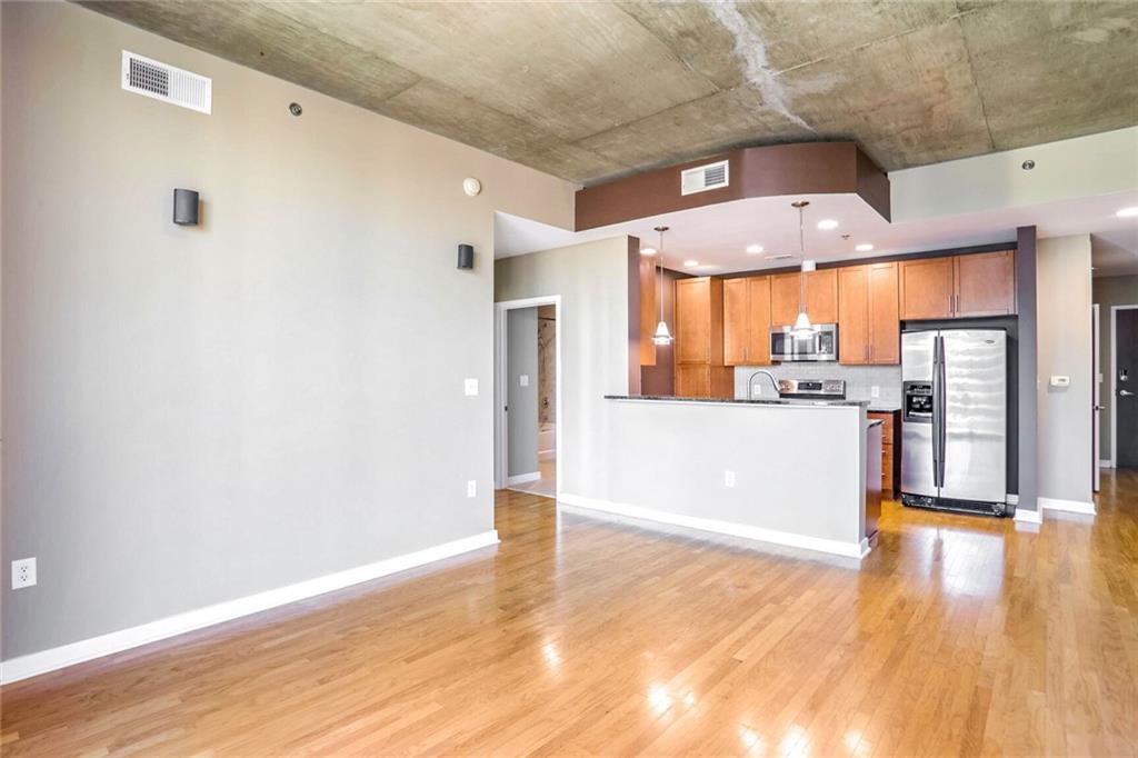 a view of a kitchen with a refrigerator a microwave and cabinets