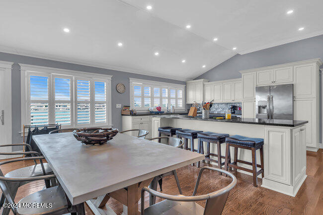 a kitchen with a dining table chairs and refrigerator