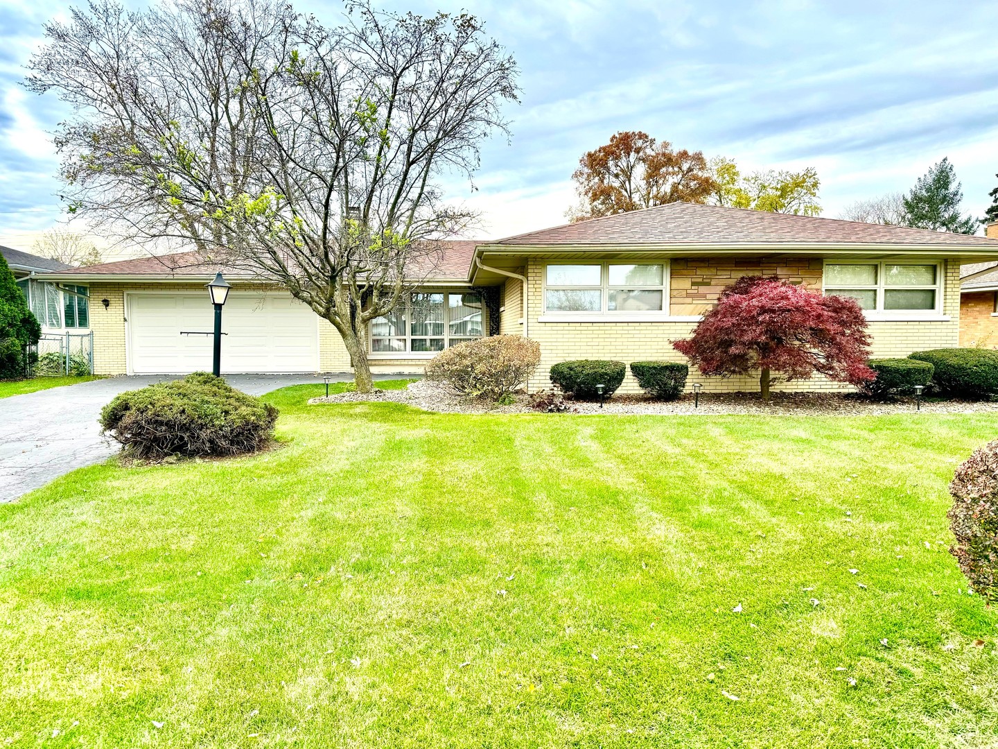 a view of a house with a big yard and potted plants