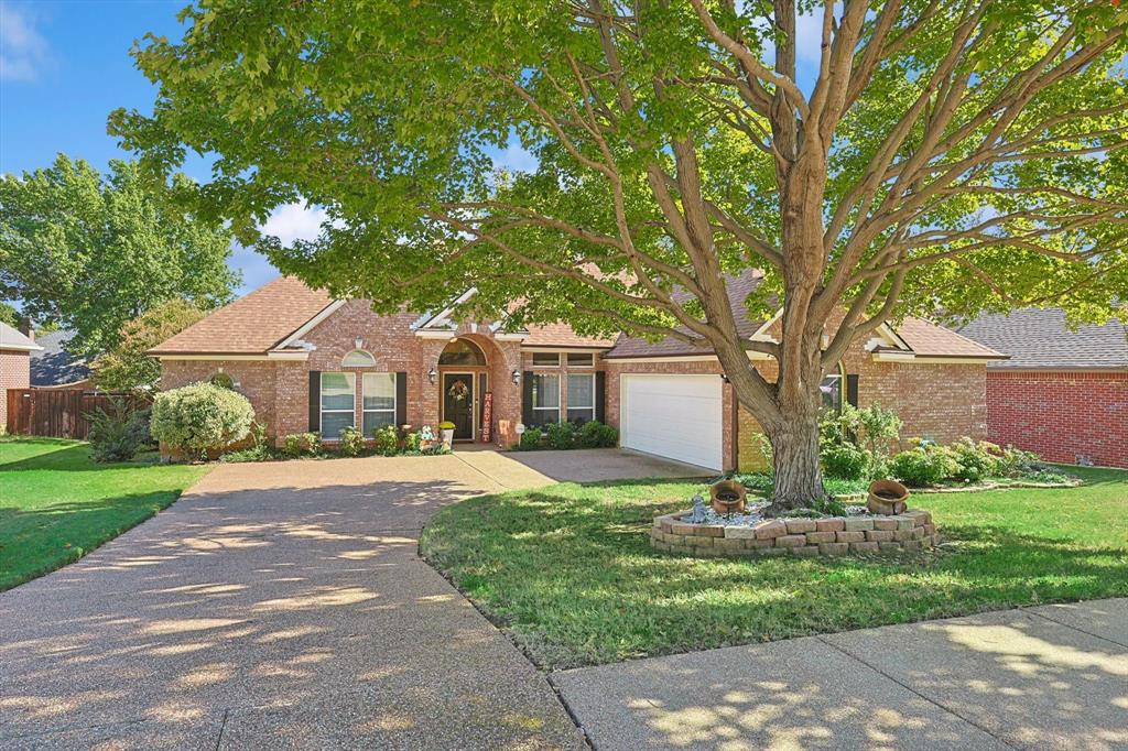 a front view of a house with a yard and trees