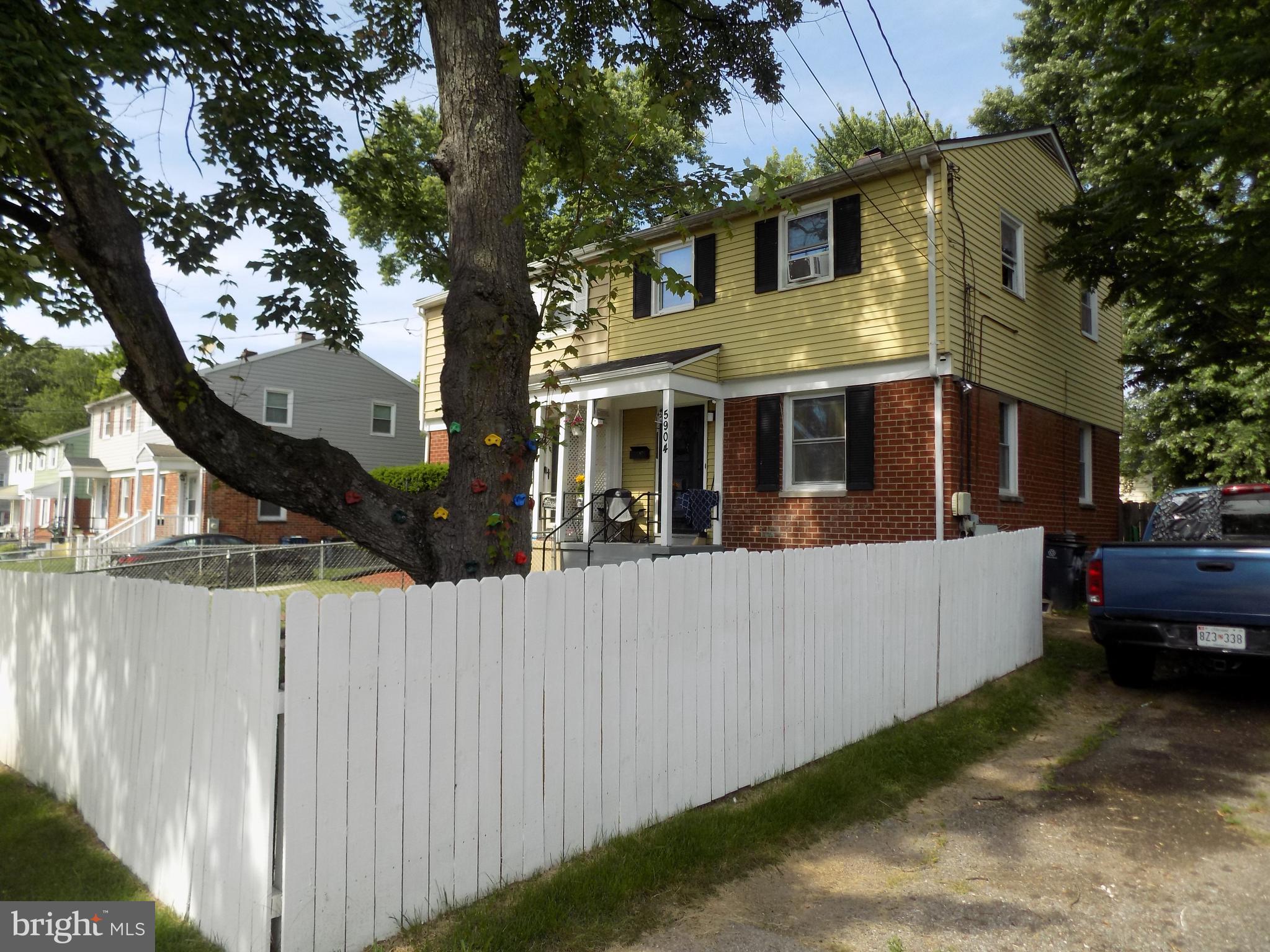 a front view of a house with a tree