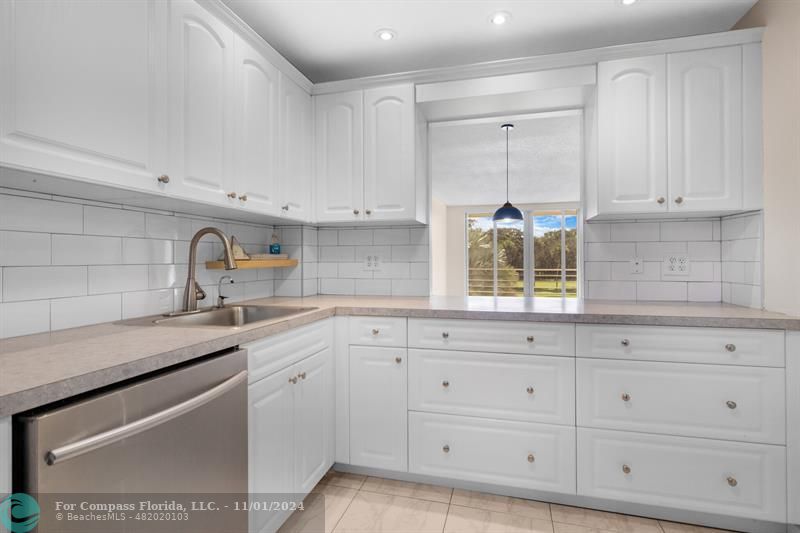 a kitchen with white cabinets and a sink