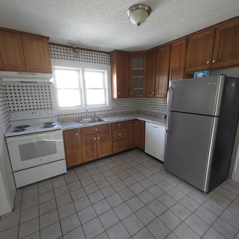 a kitchen with a stove sink and cabinets