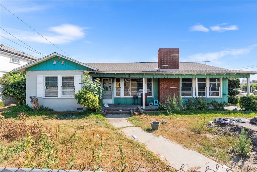 a front view of a house with a yard and potted plants