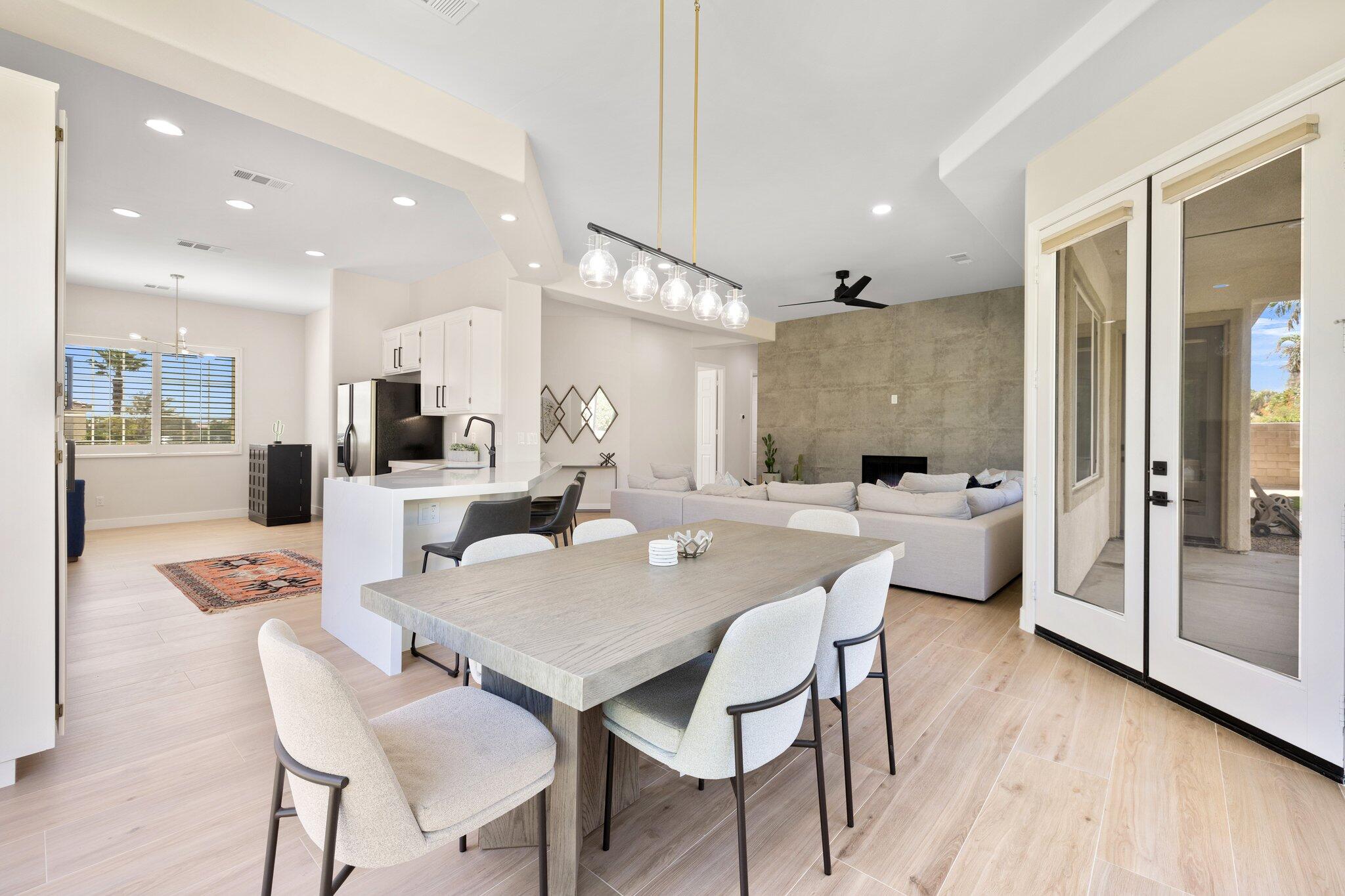 a dining room with stainless steel appliances kitchen island granite countertop a dining table chairs and view living room