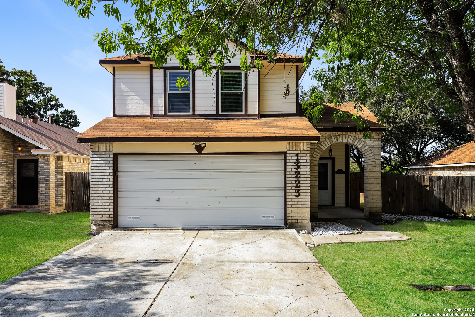 a front view of a house with a garden and garage