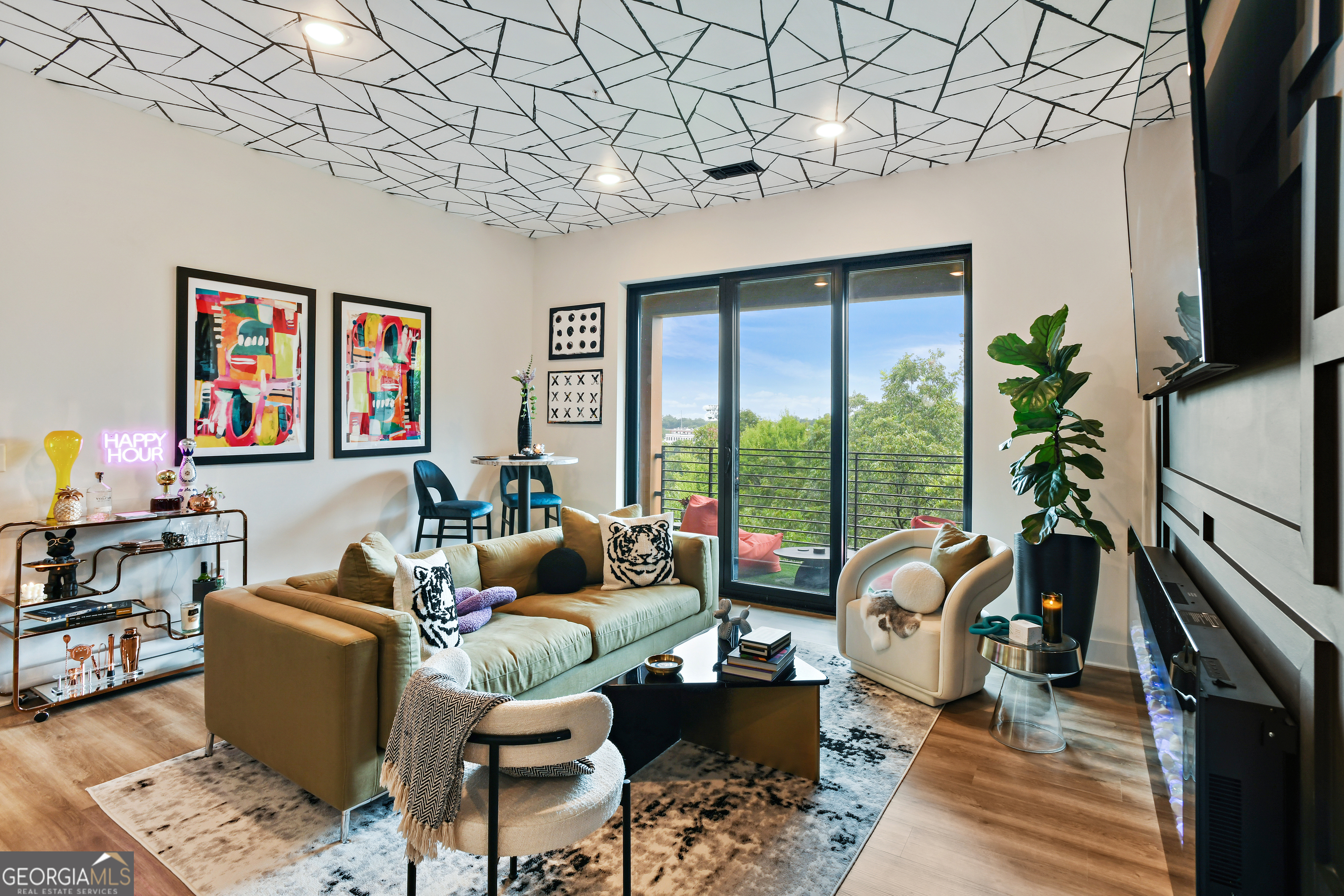 a living room with furniture a flat screen tv and a floor to ceiling window