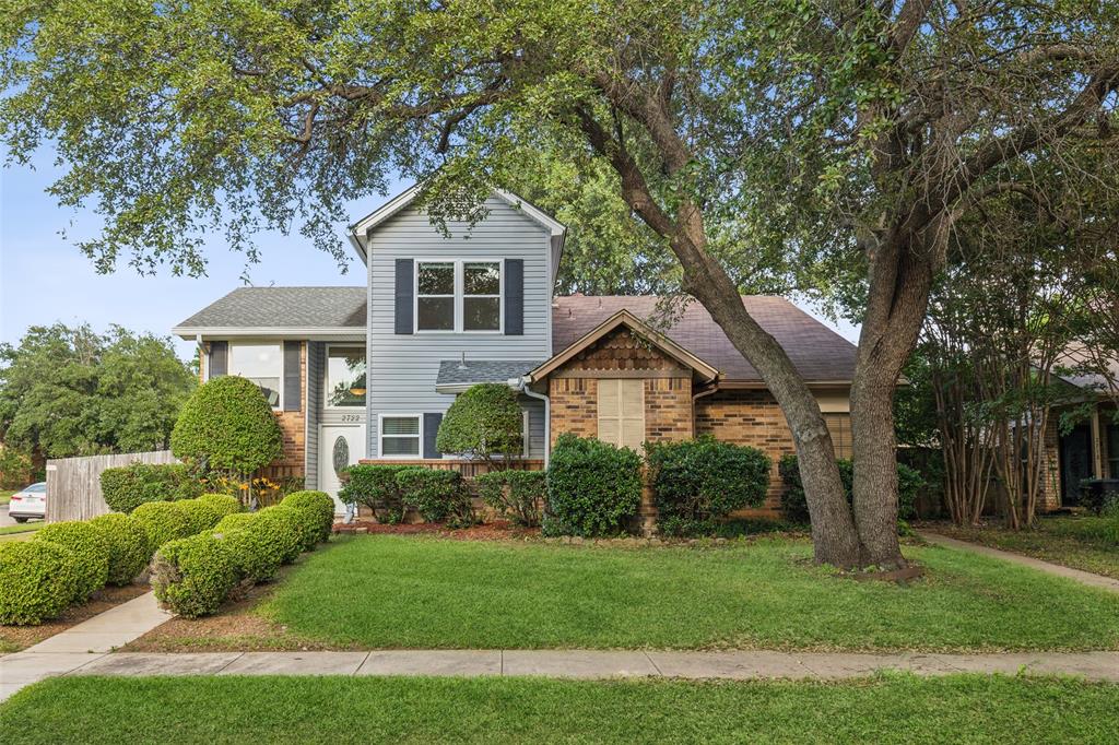 a front view of a house with a yard and trees