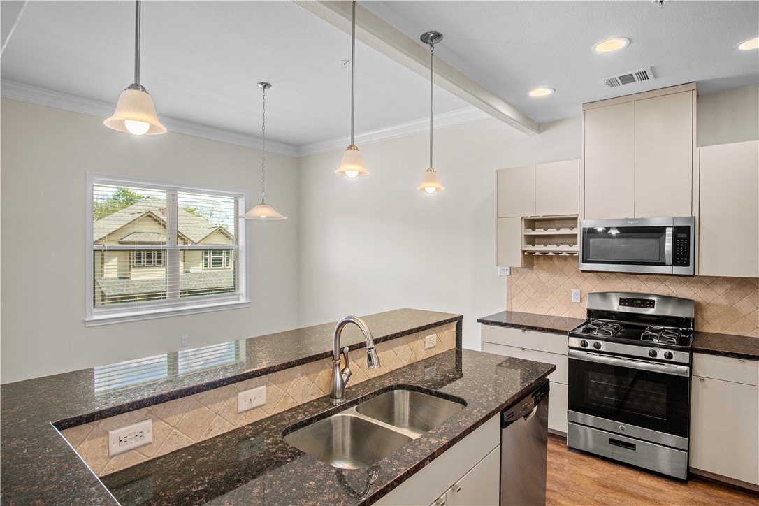 Kitchen with dark stone countertops, pendant light