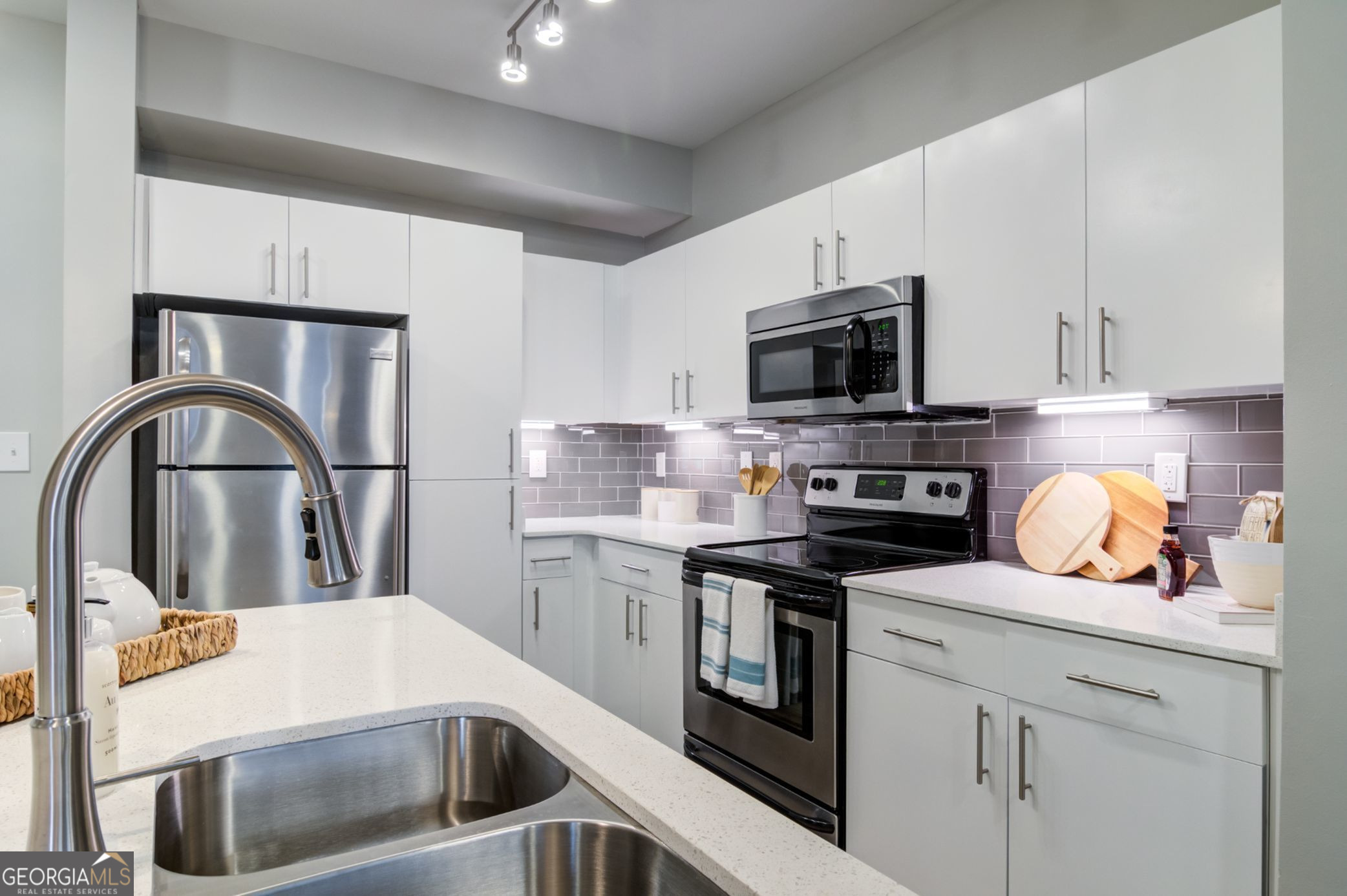 a kitchen with appliances a sink and cabinets