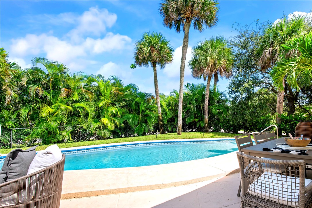 a view of a swimming pool with a patio and a yard