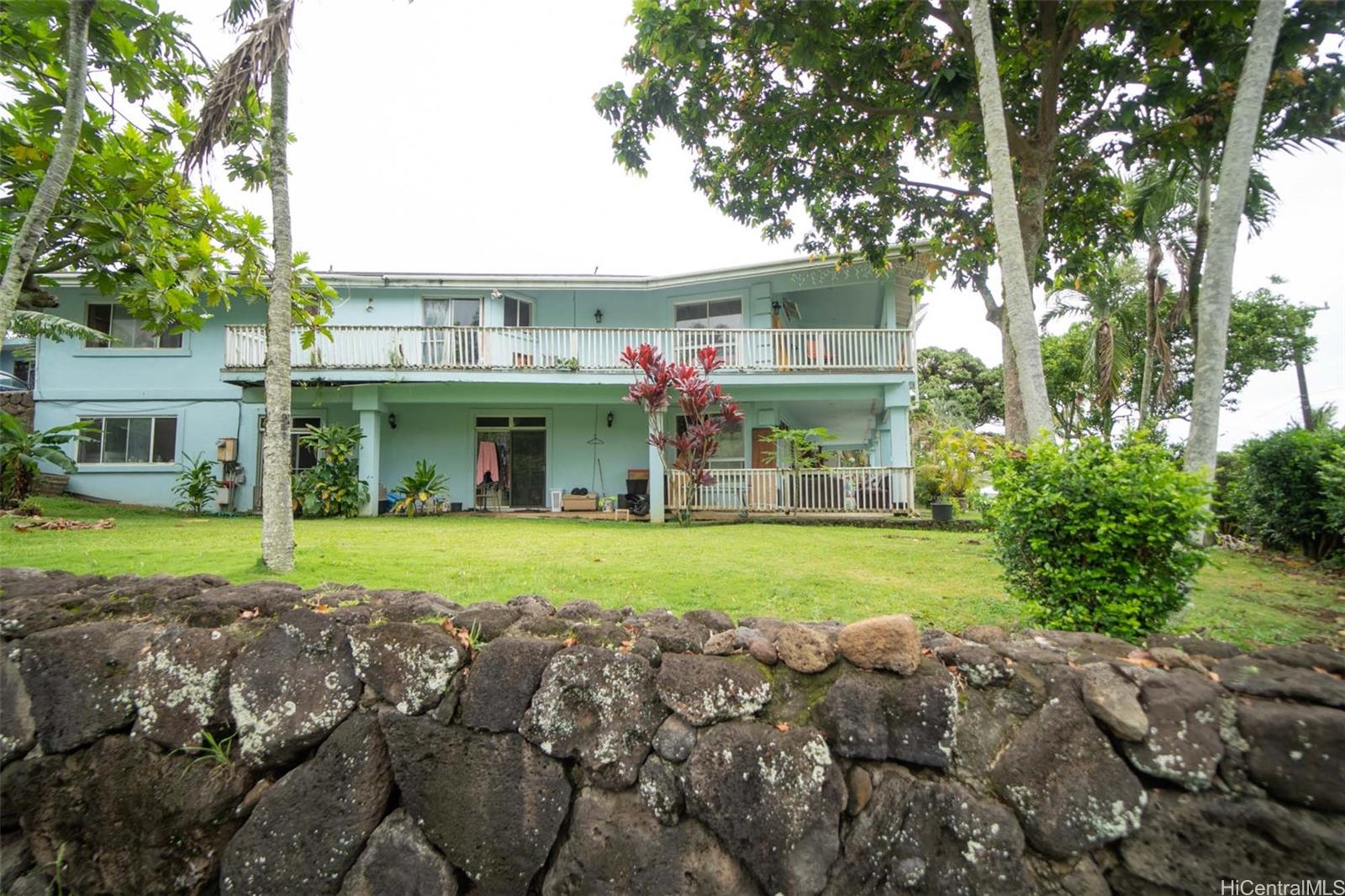 a front view of a house with a yard and trees