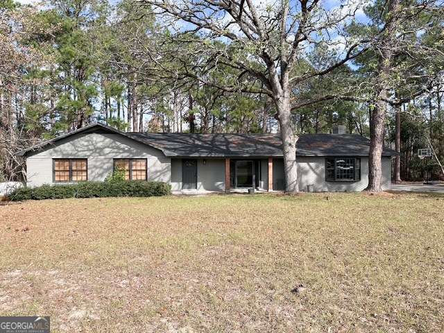 a front view of a house with yard and trees